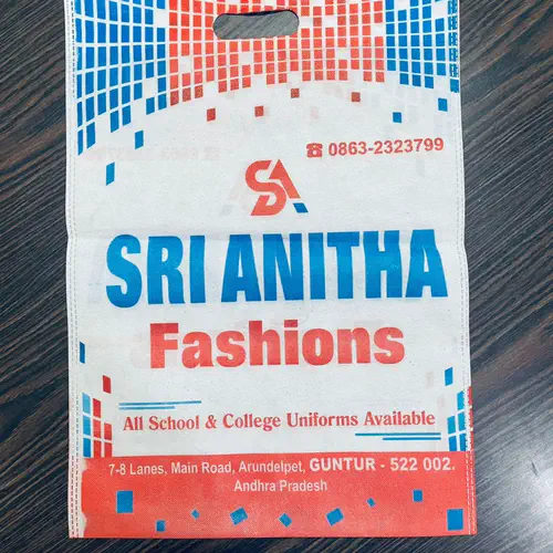 D-cut white non woven carry bag with blue and red printing, made for a clothing shop in Guntur