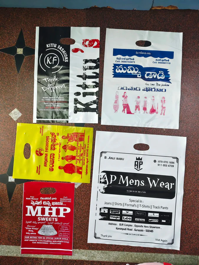 Misprinted plastic D-cut covers printed for clothing and sweet shops, laid out on a floor