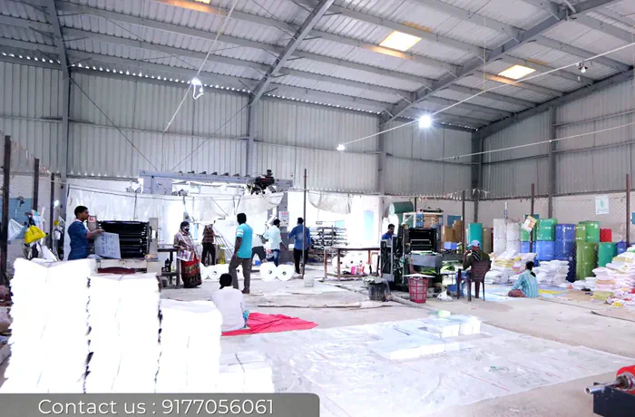 Wide view of the production hall with printing machines, stacked finished bags and workers